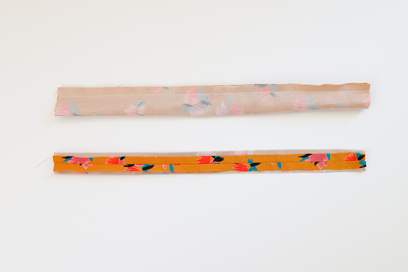 Two Marcel pattern strap pieces are shown against a white background. One is folded lengthwise with stitching across the top. The other is turned right side out and pressed flat with the seam centered.