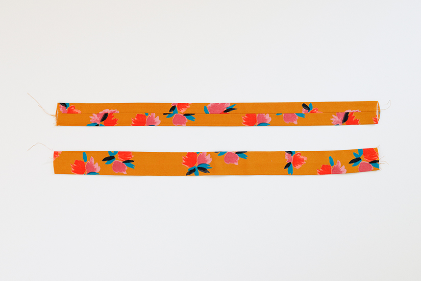 Two Marcel pattern strap pieces are shown against a white background. Both are turned right side out and pressed flat with the seam centered. 