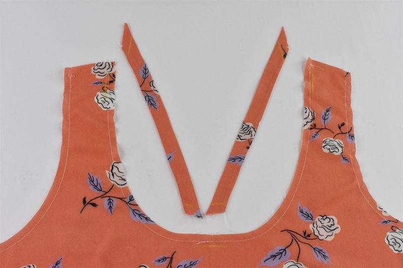 Coral fabric strap pieces and front bodice neckline are shown on a white background.