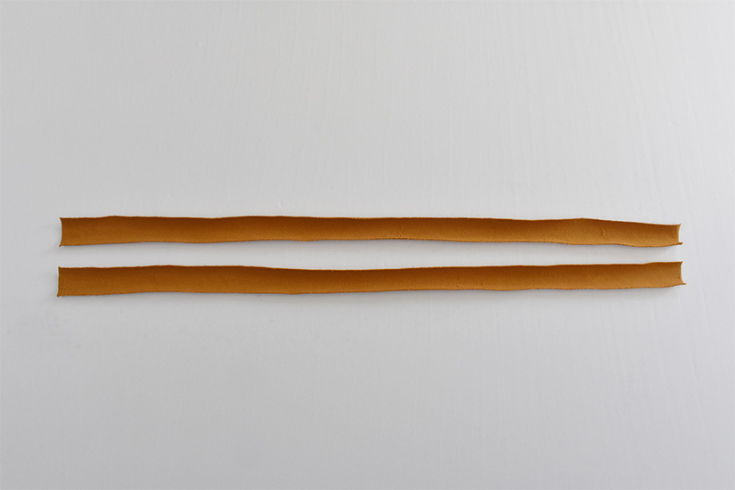 Two long thin strips of yellow knit fabric