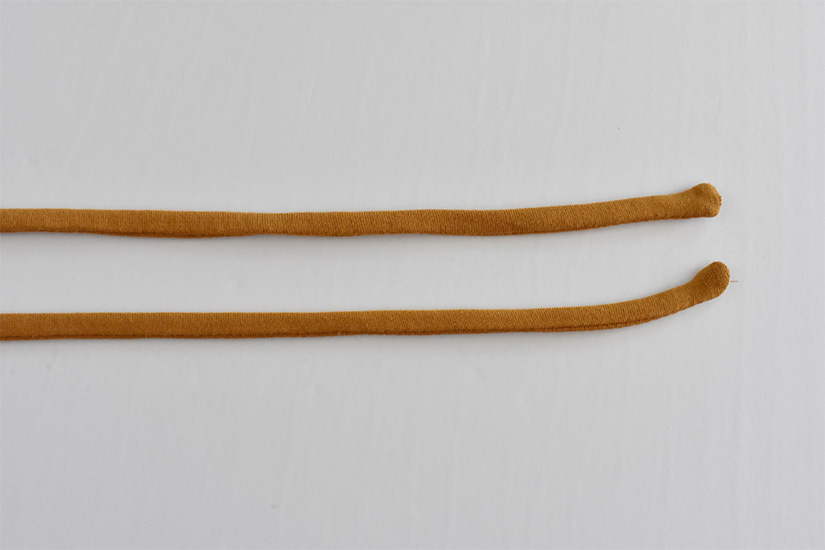 Two sewn yellow fabric tubes are shown right side out.