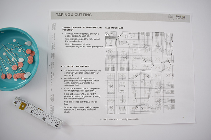 A cutting and assembling layout page of a pdf sewing pattern tutorial is shown next to a magnetic pin dish. 