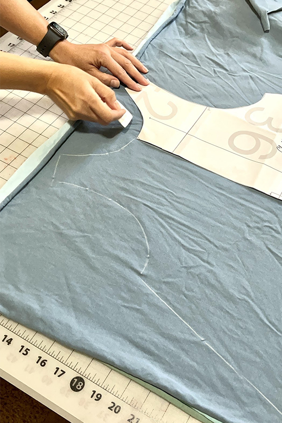 A pattern and a chalk outline are shown on blue fabric