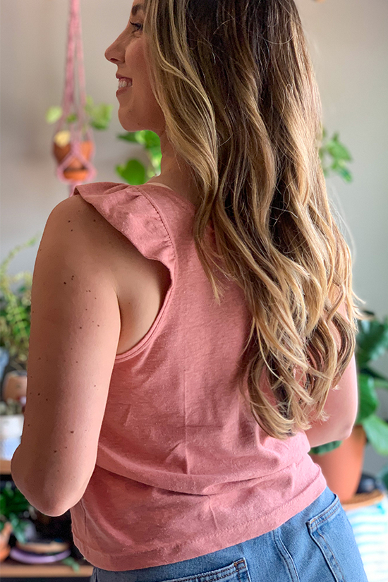 A close up view of the pink ruffle band on a Pony tank top. 