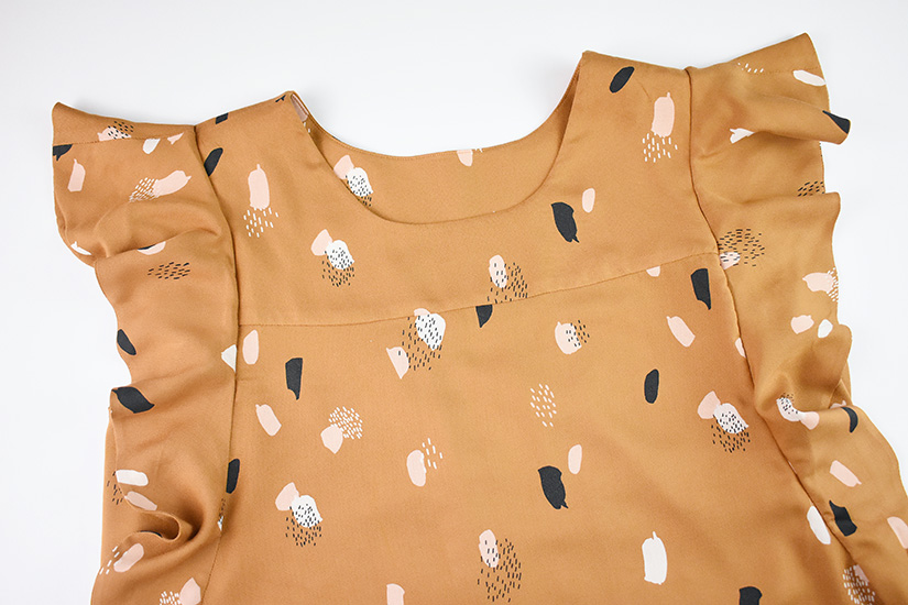 A flat lay of the ruffle sleeve view of the Farrah Blouse and Dress pattern.