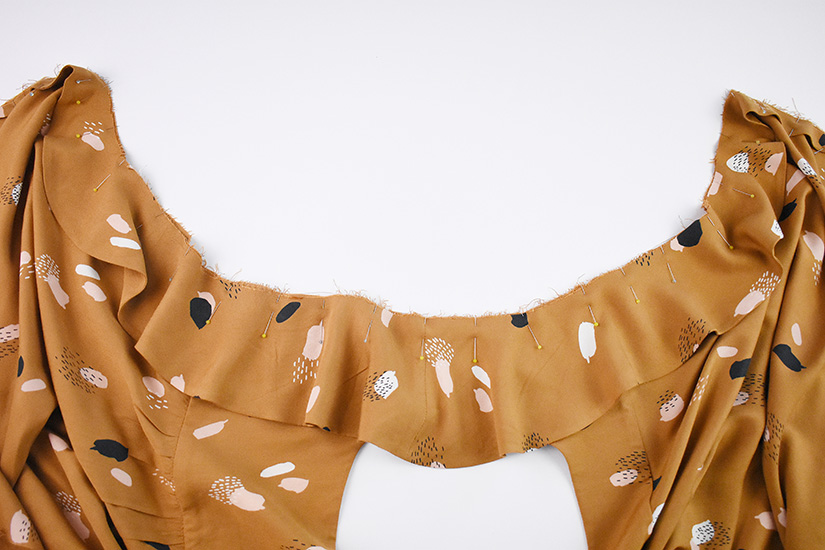 The ruffle sleeve of the Farrah sewing pattern is shown pinned to the front and back bodice.