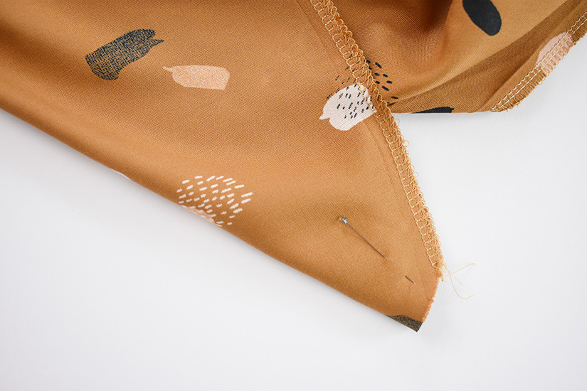 The mitered corner of the Farrah hem is shown pinned.