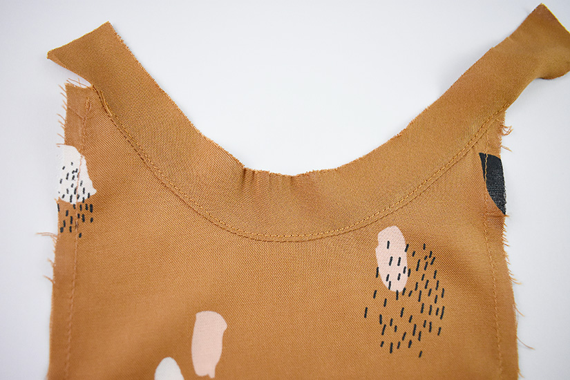 The armhole bias of the Farrah sewing pattern is shown attached, pressed, and understitched to the gusset.