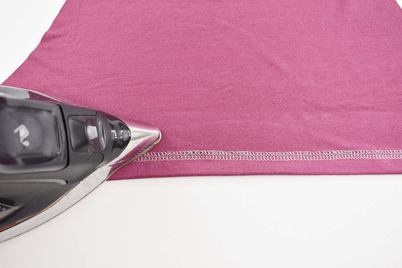 An iron presses a hem up.