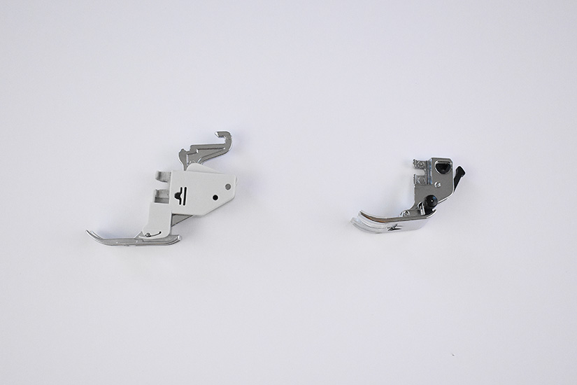 Two types of sewing machine feet lay on a white background. 