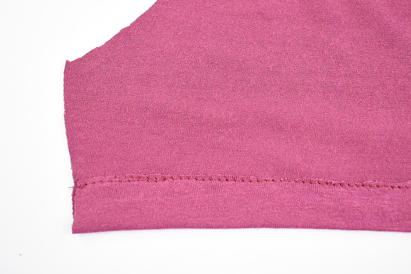 The inside of a sewn straight stitch hem is shown. 