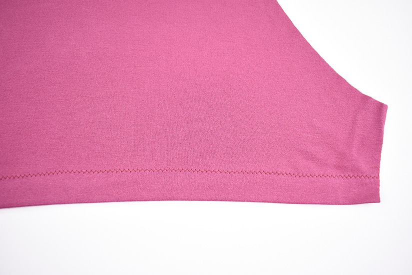 A zig zag hem is shown sewn on a pink fabric. 