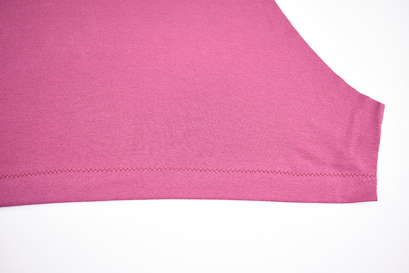 A zig zag hem is shown sewn on a pink fabric.