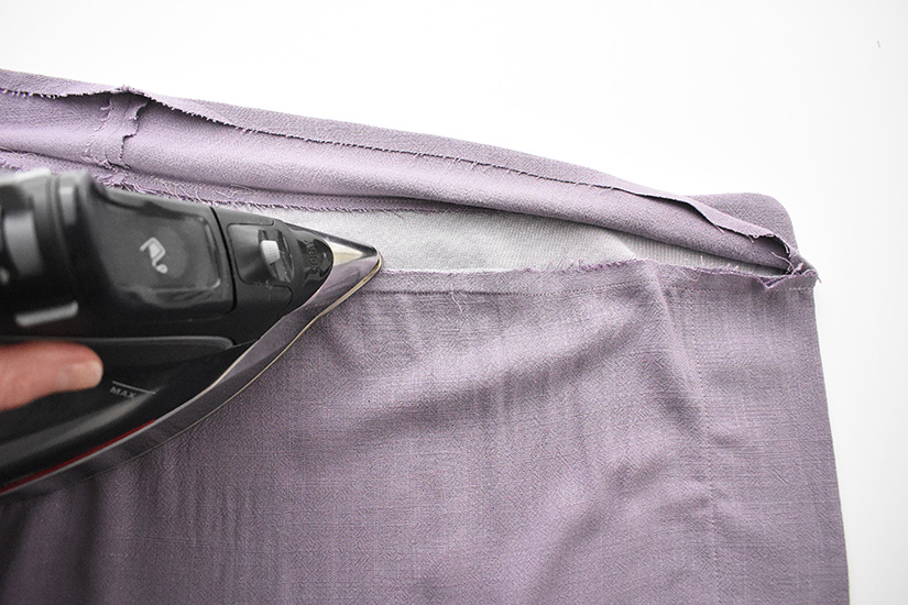 An iron presses the seam between the waistband and and skirt of the Evelyn. 