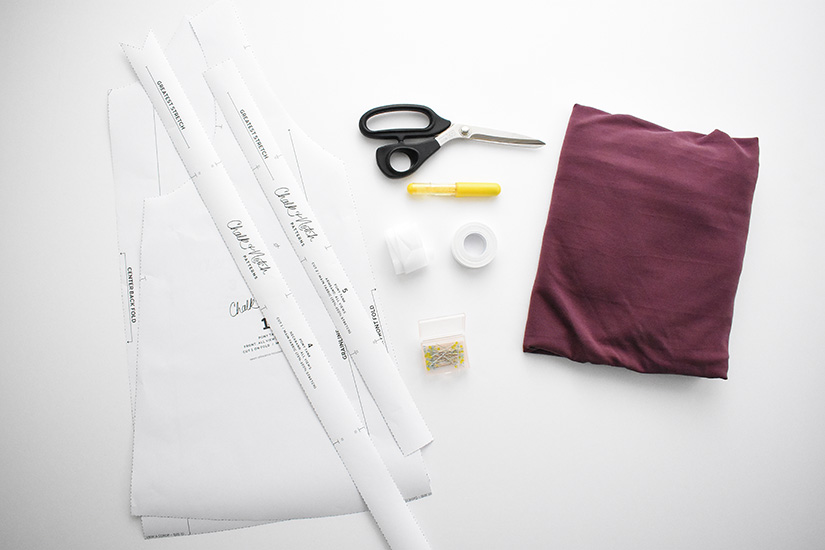 Fabric, a paper pattern and sewing supplies for the Pony Tank are laid on a white background. 