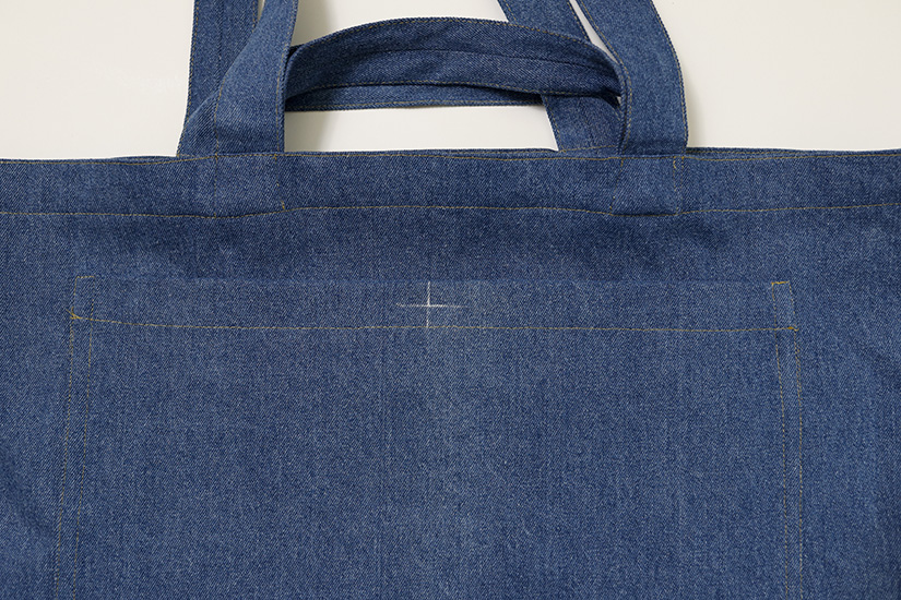 A close up of the Sun Tote exterior pocket shows a chalk marking at the top center. 
