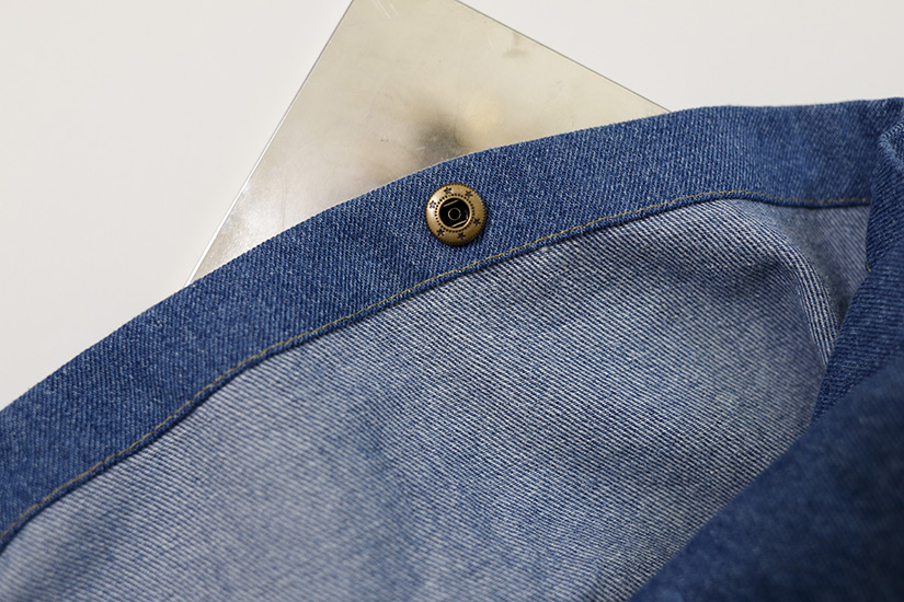 The wrong side of the snap is shown attached to the inside of the Sun tote front pocket. 