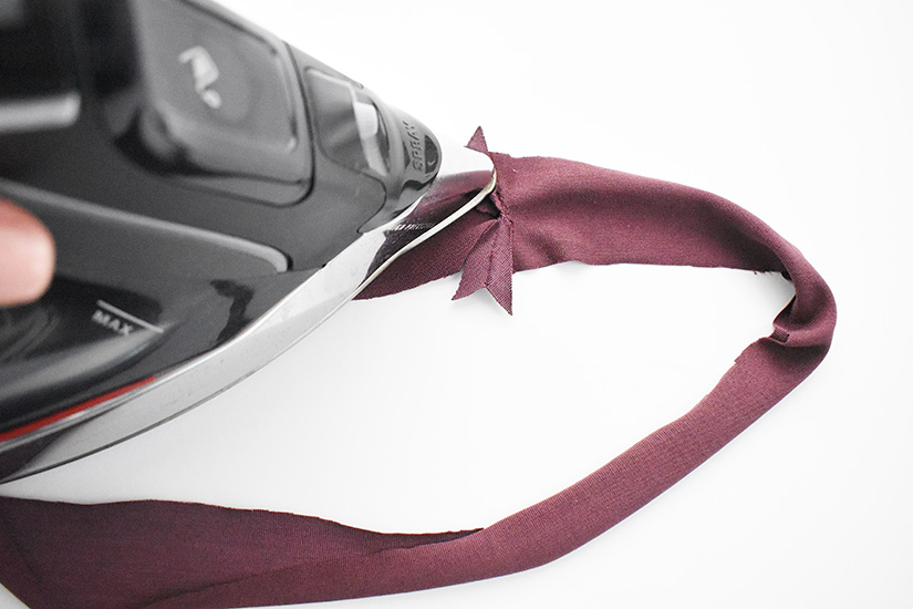 An iron presses the Pony Tank neckband.