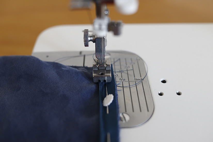 An invisible zipper foot sews on a zipper. 