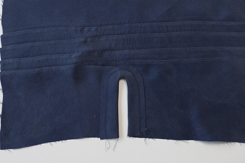The sleeve placket facing is pressed to inside of fabric. 